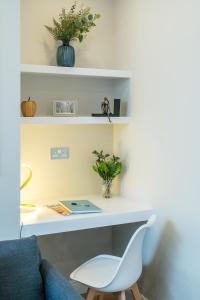 a desk with a chair and a laptop on it at Tabard House Apartment London Bridge In City Of London in London