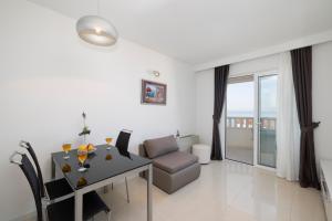 a white living room with a table and a couch at Villa 3M in Tučepi