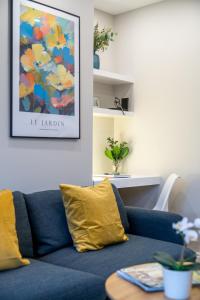 a blue couch with yellow pillows in a living room at Tabard House Apartment London Bridge In City Of London in London