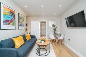 a living room with a blue couch and a table at Tabard House Apartment London Bridge In City Of London in London