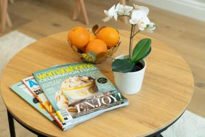 a table with a magazine and oranges and a flower at Tabard House Apartment London Bridge In City Of London in London