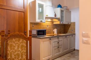 a kitchen with white cabinets and a microwave at Agriturismo il Casato Mag-il Giogo in Pienza
