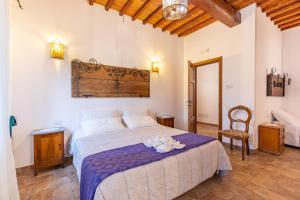 a bedroom with a bed and a table with flowers on it at Agriturismo il Casato Mag-il Giogo in Pienza