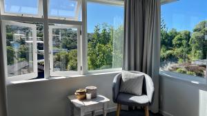 a room with a chair and a large window at Stay on Glanmire in Wellington