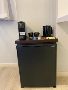 ein schwarzer Kühlschrank mit zwei Kaffeemaschinen darüber in der Unterkunft Pension Txingurri in Astigarraga