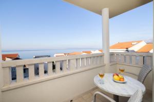 a balcony with a table and two glasses of wine at Villa 3M in Tučepi
