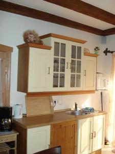 a kitchen with white cabinets and a sink at Fewo Schlangenkönig in Lehde