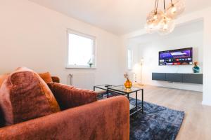 uma sala de estar com um sofá e uma televisão em Ferienwohnung für 4: WiFi, Küche, Netflix, Zentral em Bad Neuenahr-Ahrweiler