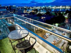 a balcony with a table and chairs and a view of a city at Superb Views Overseeing Albert Park 1BR Apartment in Melbourne