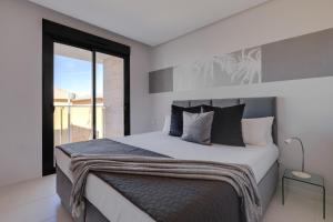 1 dormitorio con cama grande y ventana grande en BIOKO Holiday Apartment, en Cabo Roig