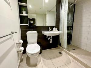 a bathroom with a toilet and a sink at Superb Views Overseeing Albert Park 1BR Apartment in Melbourne