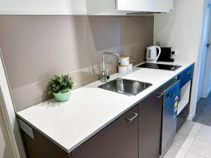 a kitchen with a sink and a counter top at Superb Views Overseeing Albert Park 1BR Apartment in Melbourne