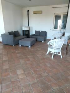 uma sala de estar com sofás, uma mesa e cadeiras em Casa Rosa Isola em Carrozziere