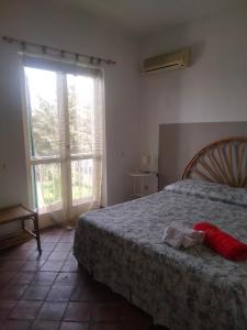 um quarto com uma cama e uma grande janela em Casa Rosa Isola em Carrozziere