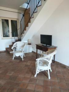 uma sala de estar com duas cadeiras de vime e uma televisão em Casa Rosa Isola em Carrozziere