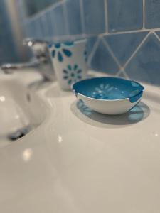 niebiesko-biała miska na zlewie w łazience w obiekcie Casa Ada romantico appartamento w mieście Chia