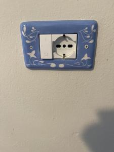 a blue lightswitch on a wall with a face on it at Casa Ada romantico appartamento in Chia