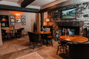 a restaurant with tables and chairs and a fireplace at The Ashford Arms in Bakewell