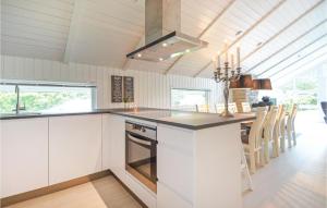 a kitchen with white cabinets and a stove top oven at Four-Bedroom Holiday Home In Spottrup in Spottrup