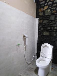 a bathroom with a toilet with a water hose at ARROW Haputale village inn in Haputale