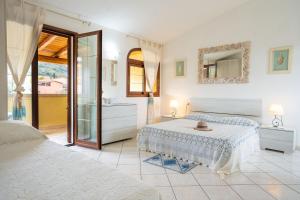 a white bedroom with two beds and a mirror at Angel Village in San Teodoro +50 photos