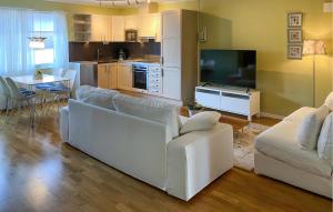 a living room with a white couch and a tv at Amazing Apartment In Färjestaden in Färjestaden