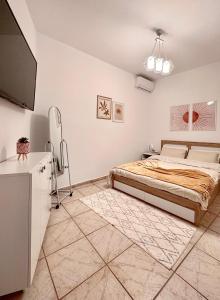 a bedroom with a bed and a flat screen tv at Filoxenia Katerini in Katerini