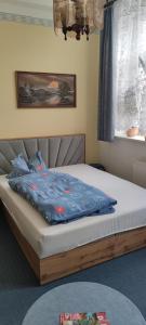 a bed with a blue blanket on it in a room at Ferienwohnung Marienkäfer in Wulkow