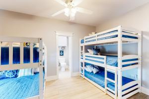 una camera con 2 letti a castello e un ventilatore a soffitto di Sunrise Beach House a Galveston