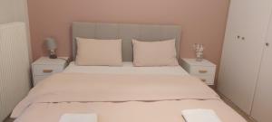 ein Schlafzimmer mit einem großen Bett mit weißen Laken und Kissen in der Unterkunft Hermes green in Artemida