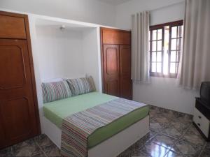 a small bedroom with a bed and a window at Maison Aires Malcher in Maricá