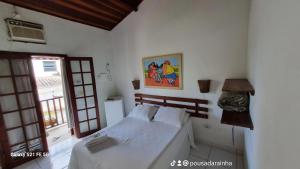 een slaapkamer met een bed en een foto aan de muur bij Pousada Rainha do Mar in Paraty