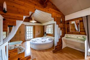 a bedroom in a log cabin with a bed and a tub at Wooden Stories in Isthmia