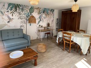 - un salon avec un canapé bleu et une table dans l'établissement LA PAUSE, à Saint-Georges-sur-Cher