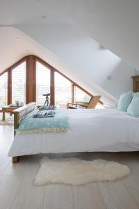 a bedroom with a large white bed with a large window at Tranquil Family Retreat 5 min to Beach Garden in West Wittering
