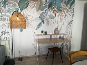 Zimmer mit einem Schreibtisch und einer Pflanzenwand in der Unterkunft LA PAUSE in Saint-Georges-sur-Cher