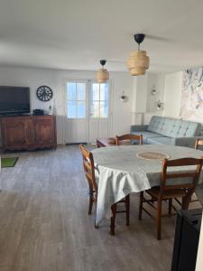 ein Wohnzimmer mit Tisch und Stühlen und einer Couch in der Unterkunft LA PAUSE in Saint-Georges-sur-Cher
