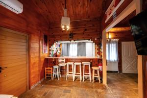 a kitchen with wooden walls and a bar with stools at Wooden Stories in Isthmia