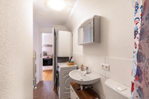 małą łazienkę z umywalką i lodówką w obiekcie Apartmenthaus Ferienwohnungen Sila w mieście Weinstadt
