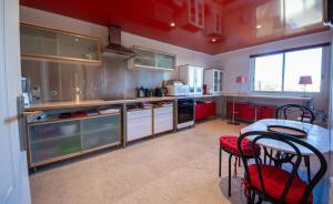 cocina con armarios rojos, mesa y sillas en Rooftop, Sea view, facing the Harbor, near Center and Beach, en Antibes