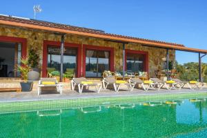 a resort with a swimming pool and chairs and a building at Villa Silence Lux with Pool in Nature and Aircon in Maçanet de la Selva