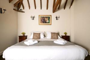 a bedroom with a large white bed with two pillows at Bull Pen and Cart Lodge in Herstmonceux