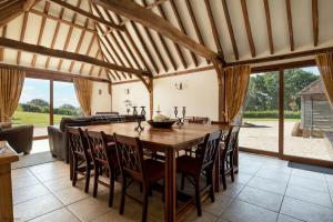 a large dining room with a wooden table and chairs at Bull Pen and Cart Lodge in Herstmonceux