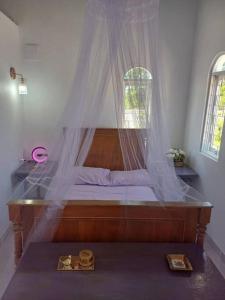a bedroom with a bed with a mosquito net at Casa do Mato II in São Lourenço do Sul