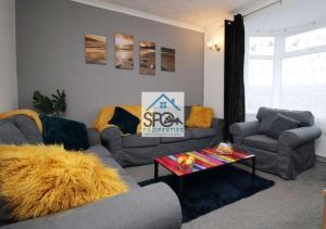 a living room with two couches and a table at Modern 4BR Home-7 Guests-Business-Families-Netflix-Free Parking & WiFi in Pontnewynydd