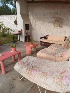 a patio with two tables and a couch and a bench at Casa do Mato II in São Lourenço do Sul