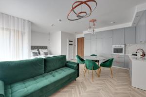 a living room with a green couch and a table at Downtown Apartments Riverside Nadmotławie - Parking, Sauna & Gym in Gdańsk