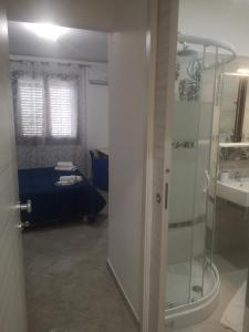 łazienka z prysznicem oraz sypialnia z łóżkiem w obiekcie Casa vacanza da Samuele w mieście San Vito lo Capo