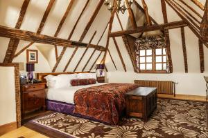 a bedroom with a bed in a room with beams at Lainston House in Winchester