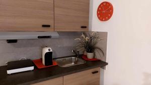 una cocina con fregadero y un reloj en la pared en B&B GoodDay Roma Tor Vergata, en Tor Vergata